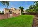 Large, grassy backyard with a brick retaining wall and a wooden fence at 11532 Newland St, Westminster, CO 80020
