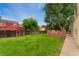A spacious backyard featuring green grass, a wooden fence, and a brick patio structure at 11532 Newland St, Westminster, CO 80020