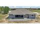 Aerial back view of house with covered patio overlooking large yard and nearby open fields at 1180 Antelope W Dr, Bennett, CO 80102