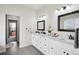 Bathroom with dual sinks, white cabinets, and framed mirrors, providing a clean and functional space at 1180 Antelope W Dr, Bennett, CO 80102