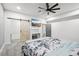 Bright bedroom with a barn door, TV, ceiling fan, and closet for ample storage at 1180 Antelope W Dr, Bennett, CO 80102