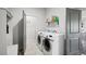 Functional laundry room with modern machines and convenient storage shelves at 1180 Antelope W Dr, Bennett, CO 80102