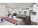 Open concept living space featuring a modern kitchen, dining area with statement table, and comfortable living room at 1180 Antelope W Dr, Bennett, CO 80102