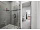 Modern tiled shower with glass door, rainfall showerhead, and mosaic accents, adding a touch of elegance at 1180 Antelope W Dr, Bennett, CO 80102