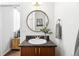 Chic bathroom boasts vanity with granite countertop and stylish round mirror at 2706 Blake St, Denver, CO 80205