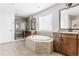 Bathroom featuring a shower with glass doors, soaking tub, and dual sinks at 973 Treece St, Louisville, CO 80027