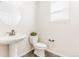 A powder room featuring a pedestal sink, neutral colors, and a framed mirror at 973 Treece St, Louisville, CO 80027