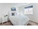 Bright bedroom with lake view art, white furniture, and a window with blinds at 973 Treece St, Louisville, CO 80027