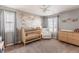 Bedroom with soft gray walls, a ceiling fan, and an accent map wall at 973 Treece St, Louisville, CO 80027