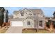 Charming two-story home with a well-manicured lawn, an attached two-car garage, and appealing architectural details at 973 Treece St, Louisville, CO 80027