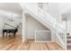 Elegant foyer featuring hardwood floors, a staircase, and a grand piano at 973 Treece St, Louisville, CO 80027