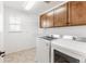 Bright laundry room features a washer, dryer, overhead cabinets, and a practical wire rack for efficient organization at 973 Treece St, Louisville, CO 80027