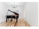 Living room featuring a chandelier, grand piano, and hardwood floors at 973 Treece St, Louisville, CO 80027