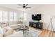 Bright living room with a cozy fireplace, a ceiling fan, and large windows at 973 Treece St, Louisville, CO 80027