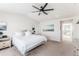 Light, airy main bedroom featuring a ceiling fan, neutral walls, and adjoining bathroom at 973 Treece St, Louisville, CO 80027