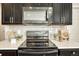 Modern kitchen features with dark cabinetry and quartz countertops at 27192 E Frost Pl, Aurora, CO 80016