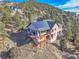 Aerial view of a home with solar panels and a large deck situated in a mountain setting at 2433 Dogie Spur, Golden, CO 80403