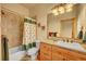 Bathroom featuring tiled shower and tub, toilet and vanity with sink, and warm neutral color palette at 2433 Dogie Spur, Golden, CO 80403