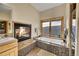 Beautiful bathroom highlighting a fireplace, soaking tub, and large window with natural light at 2433 Dogie Spur, Golden, CO 80403