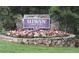 Elegant stone entrance sign to Hiwan Golf Club with floral display and manicured lawn at 2433 Dogie Spur, Golden, CO 80403