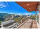 Large deck with seating area and outdoor grill overlooking mountain views at 2433 Dogie Spur, Golden, CO 80403