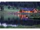 Stunning log cabin home reflecting in a serene lake at twilight, creating a peaceful ambiance at 2433 Dogie Spur, Golden, CO 80403