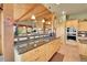 Kitchen with granite counters, custom wood cabinets, cooktop, and exposed beams at 2433 Dogie Spur, Golden, CO 80403