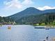 Picturesque lake view with people enjoying water activities, set against a mountain backdrop at 2433 Dogie Spur, Golden, CO 80403