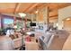 Comfortable living room with a stone fireplace and large windows showcasing the outdoor view at 2433 Dogie Spur, Golden, CO 80403