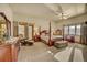 Spacious main bedroom showcasing a four poster bed, cozy seating area, and exterior door to the deck at 2433 Dogie Spur, Golden, CO 80403