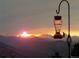 Serene sunset view over the mountains with hummingbird feeder in foreground, offering a tranquil setting at 2433 Dogie Spur, Golden, CO 80403