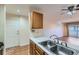 Kitchen area with double sink, wood cabinets, and views into living room at 444 S Kittredge St # 205, Aurora, CO 80017