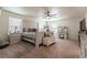 Spacious bedroom with a white bed frame and bench, complemented by a ceiling fan and plenty of sunlight at 920 William Way, Brighton, CO 80603