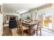 Open-concept dining room with a glass table, slider doors and seamless flow to the living area at 920 William Way, Brighton, CO 80603
