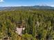 Aerial view reveals the home's location surrounded by a dense forest, showcasing its secluded and scenic setting at 91 Slalom Dr, Breckenridge, CO 80424