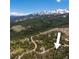 Aerial view of a wooded area with snowy mountain peaks in the background, showing the property's location at 91 Slalom Dr, Breckenridge, CO 80424