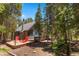 Charming exterior view of a cabin-style home nestled among mature trees with a welcoming deck and outdoor seating at 91 Slalom Dr, Breckenridge, CO 80424