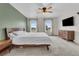 Bright bedroom featuring plush carpet, a modern ceiling fan, and plenty of natural light from the windows at 7218 Animas Ave, Frederick, CO 80530