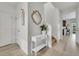 Bright entryway with a white console table, decorative mirror, and wood-look flooring at 7218 Animas Ave, Frederick, CO 80530