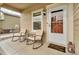 Inviting front porch with rocking chairs, welcome mat, and partially-glass front door at 7218 Animas Ave, Frederick, CO 80530