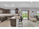 Bright kitchen with granite counters, center island with barstool seating and a sliding glass door to the backyard at 7218 Animas Ave, Frederick, CO 80530