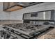 Close-up of the stainless steel gas range featuring a black cooktop and white subway tile backsplash at 7218 Animas Ave, Frederick, CO 80530