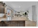 Open concept kitchen features a center island with barstool seating that flows into the living room at 7218 Animas Ave, Frederick, CO 80530