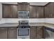 This kitchen features granite counters, subway tile backsplash, stainless steel appliances and dark cabinets at 7218 Animas Ave, Frederick, CO 80530