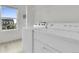 Bright laundry room with side-by-side washer and dryer, white cabinets and natural light from a large window at 7218 Animas Ave, Frederick, CO 80530