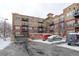 Multi-story apartment building with balconies and a parking area covered in snow during the winter at 10184 Park Meadows Dr # 1406, Lone Tree, CO 80124