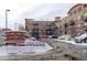 Lincoln Square Lofts building with snow-covered landscaping and visitor parking during the winter season at 10184 Park Meadows Dr # 1406, Lone Tree, CO 80124