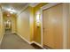 Hallway with carpet, baseboard trim, and a light fixture illuminating a unit door at 10184 Park Meadows Dr # 1406, Lone Tree, CO 80124