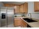 Updated kitchen showcasing stainless steel refrigerator, ample wooden cabinets, and modern fixtures at 10184 Park Meadows Dr # 1406, Lone Tree, CO 80124