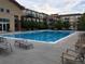 Community pool with surrounding lounge chairs and complex in background at 10184 Park Meadows Dr # 1406, Lone Tree, CO 80124